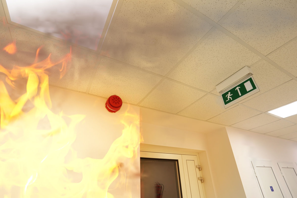 Notausgangsschild und Feuer im Flur – vorbeugender Brandschutz