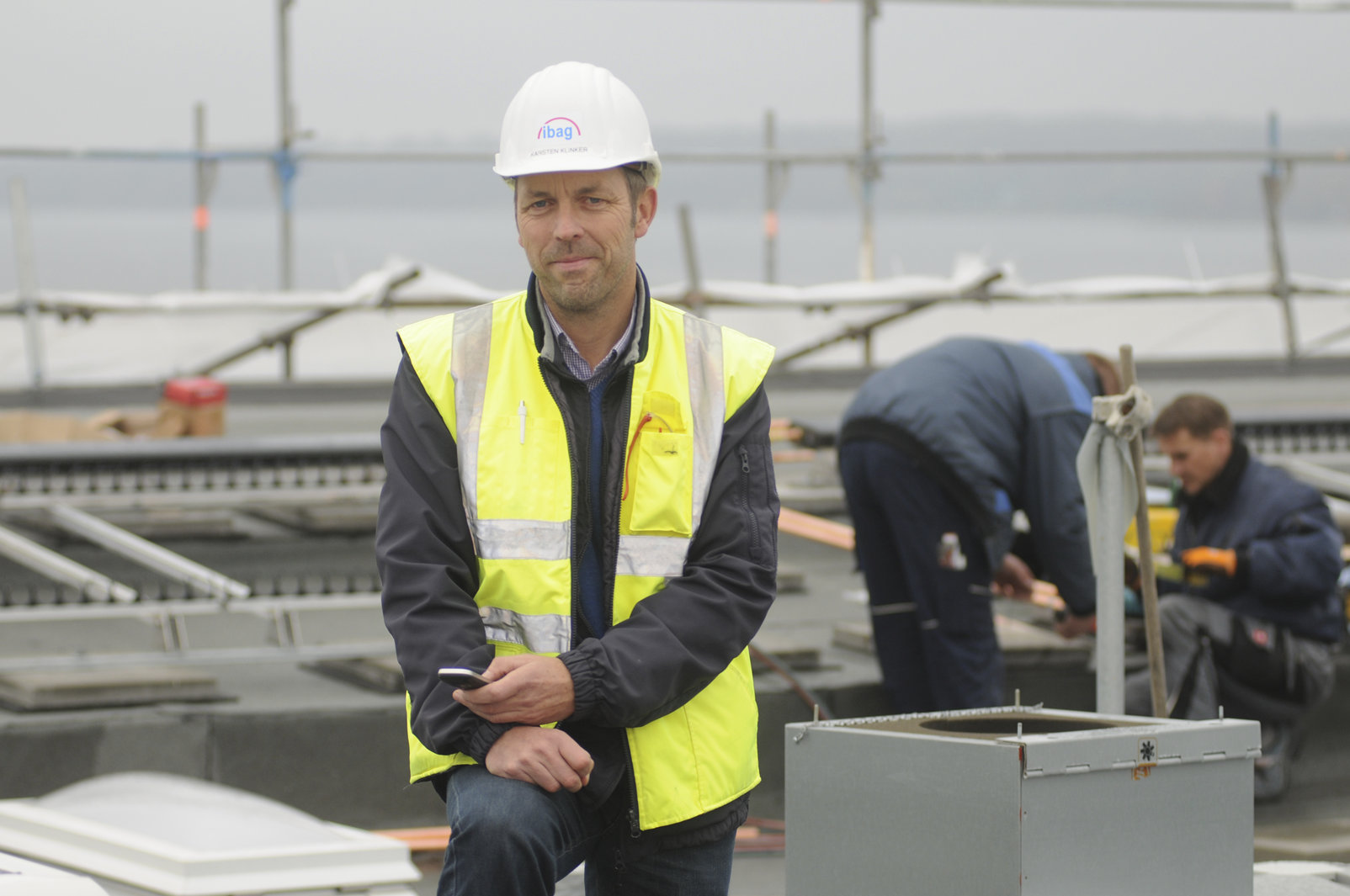 Karsten Klinker, Geschäftsführer der IBAG, mit Schutzweste und Helm auf einer Baustelle